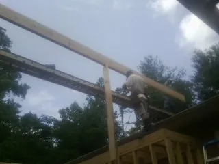 Carpenter setting a ridge beam over a new addition frame — Ice Dam Removal by Roofing Brothers in Boulevard