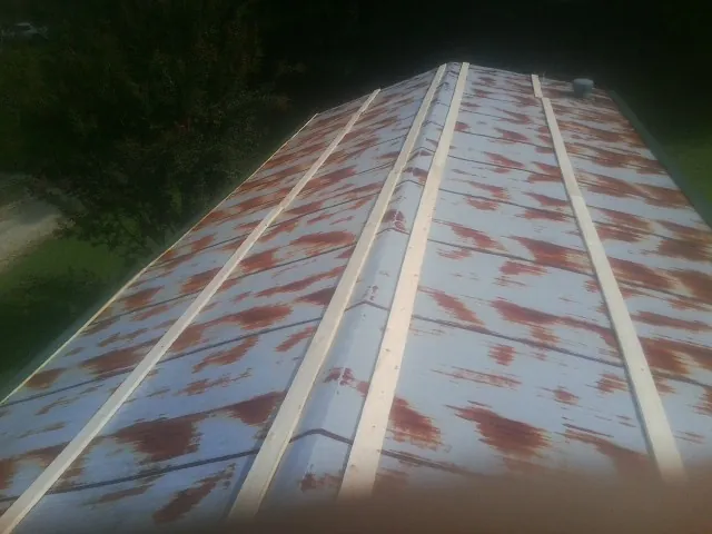Rusted metal roof panels with new wood purlins before replacement — Storm Damage Roof Repair in Boulevard by Roofing Brothers