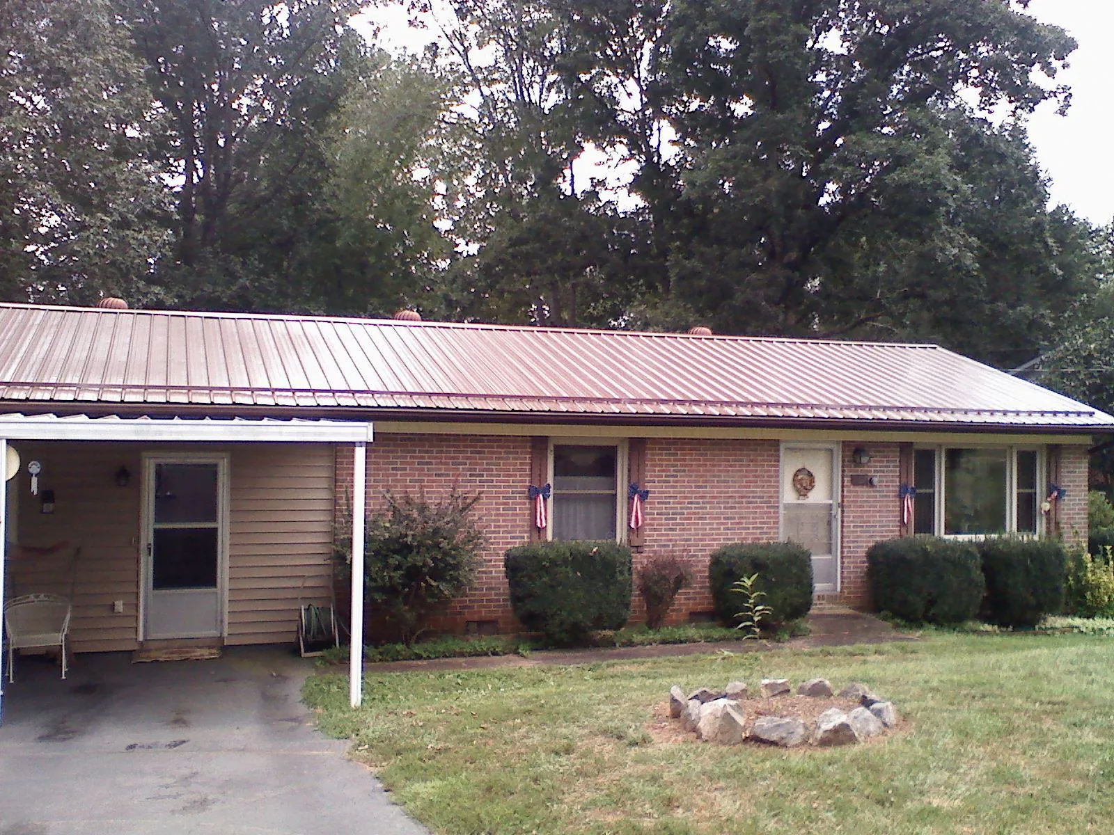 Bronze metal roof and carport on a brick ranch home — Roof Repair work by our crew in Boulevard